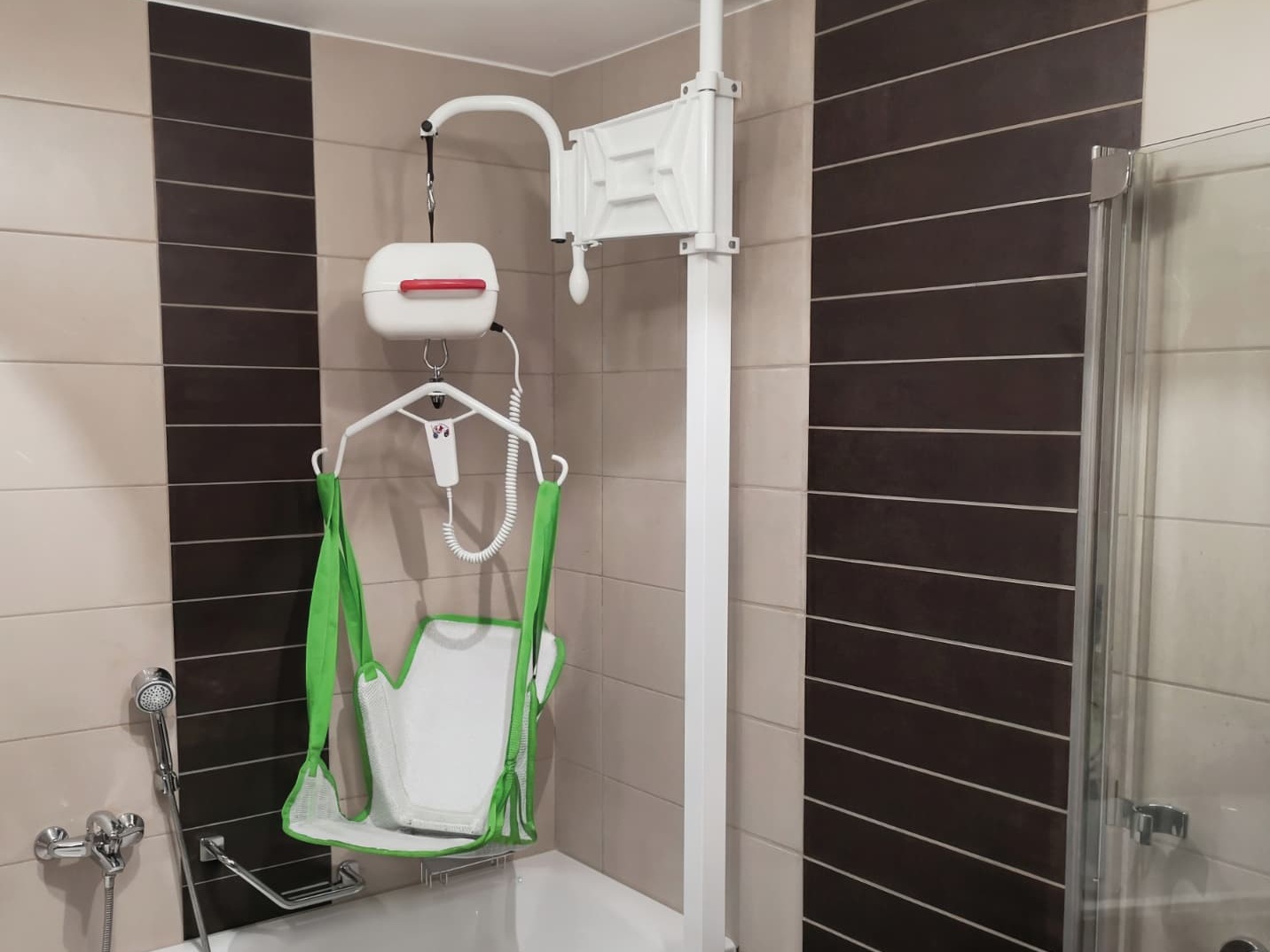 iDuMo Klemmlift mit gruenem Sitztuch gut sichtbar ueber der Badewanne